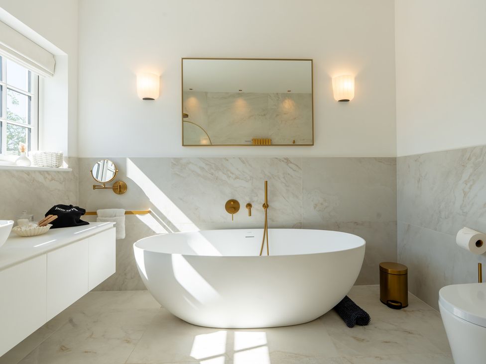 A bathroom featuring a bathtub and a sink at Sea Estate House in Rustington