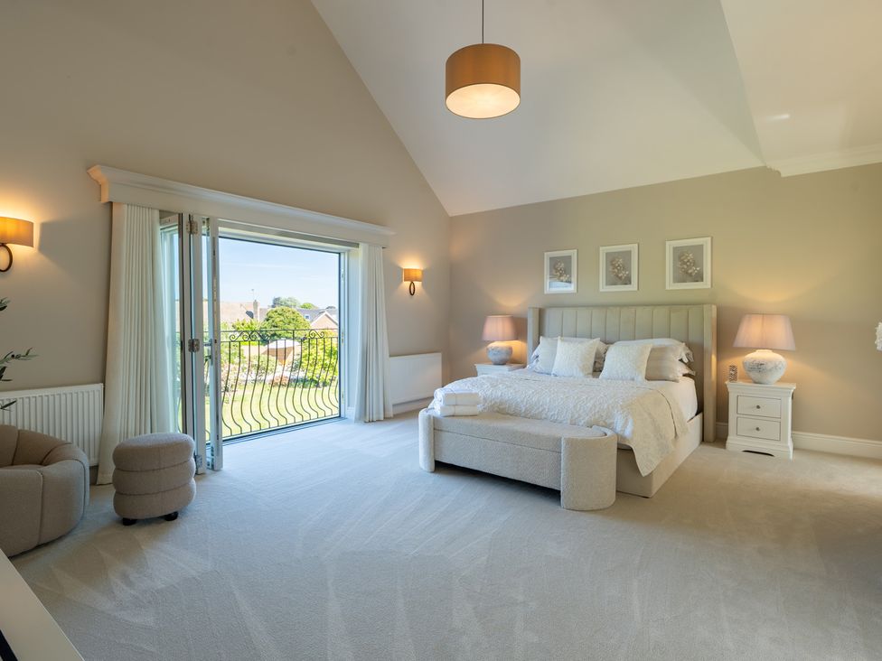 A bedroom with a bed and balcony door at Sea Estate House Rustington
