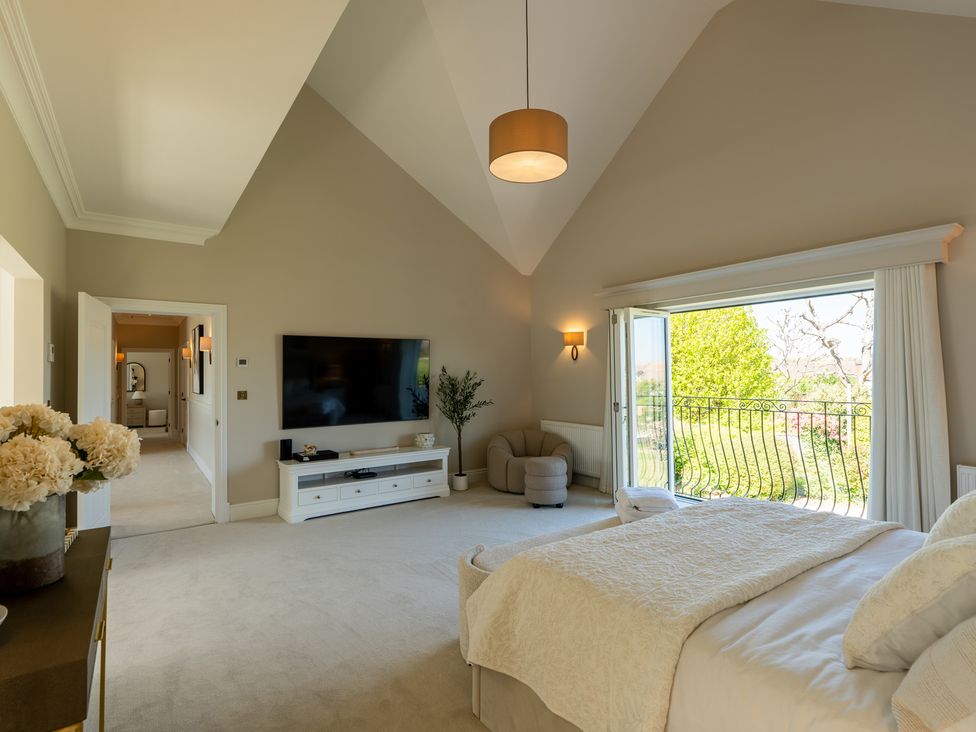 A bedroom with a bed and television at Sea Estate House in Rustington