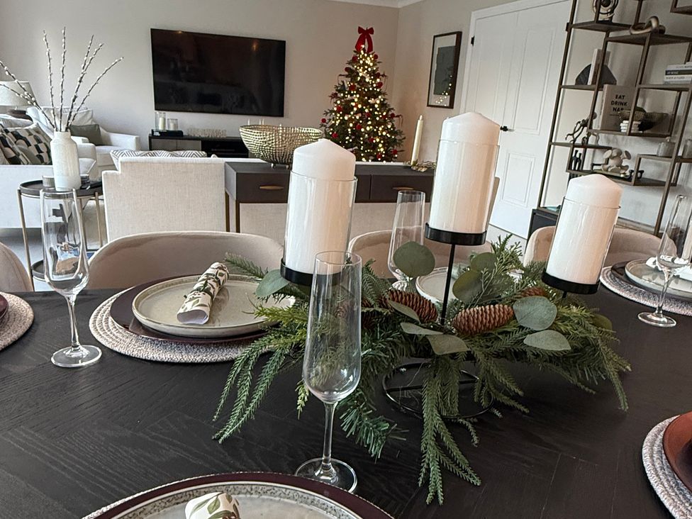 A dining room with a table set and a Christmas tree at Sea Estate House in Rustington