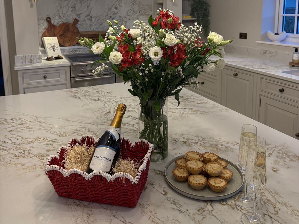 A kitchen with a bouquet of flowers and snacks at Sea Estate House in Rustington