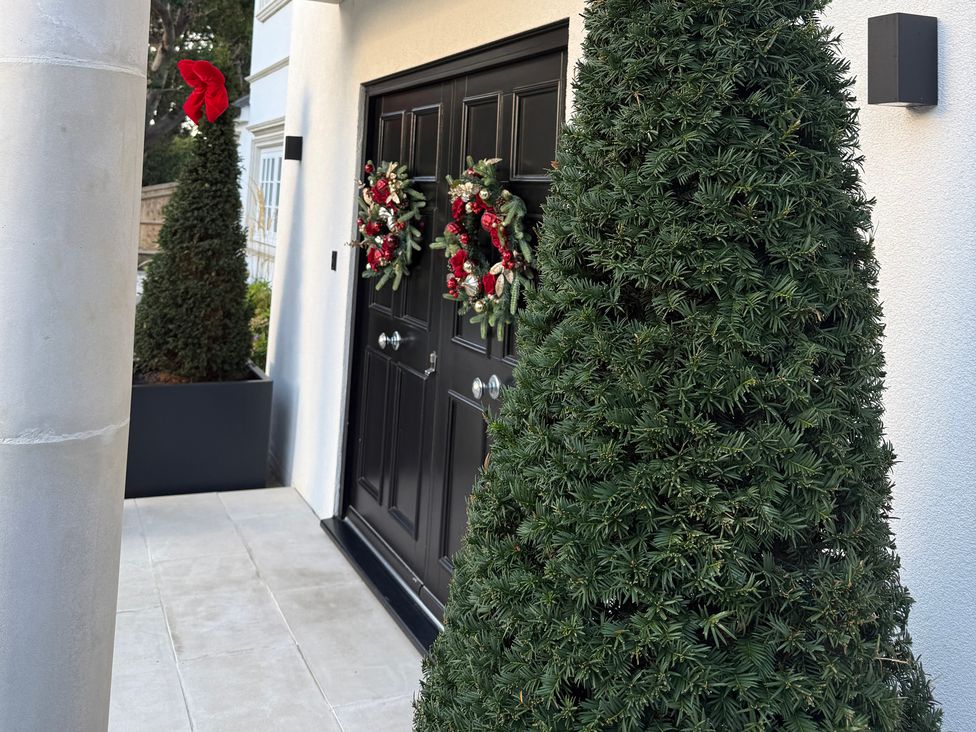 A doorway with wreaths and plants at Sea Estate House in Rustington