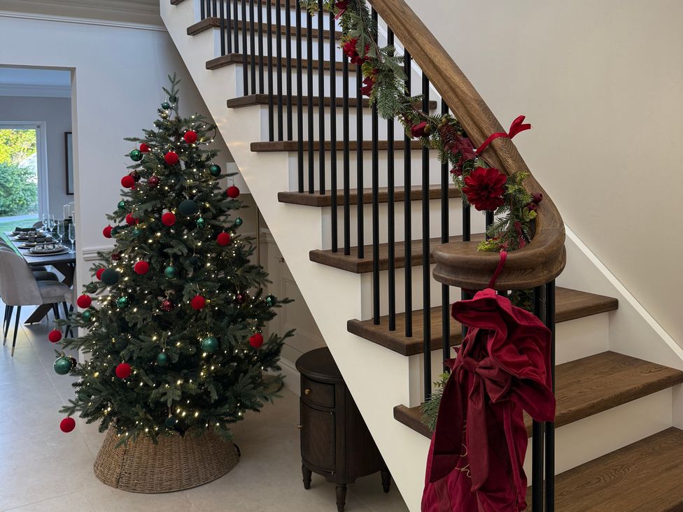 A hallway with a Christmas tree and staircase at Sea Estate House Rustington