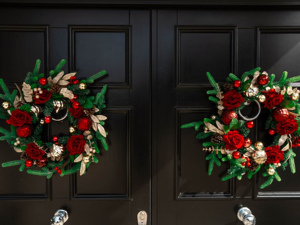 Two decorative wreaths on a black front door at Sea Estate House in Rustington