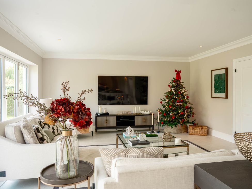 A living room with a sofa and Christmas tree at Sea Estate House in Rustington