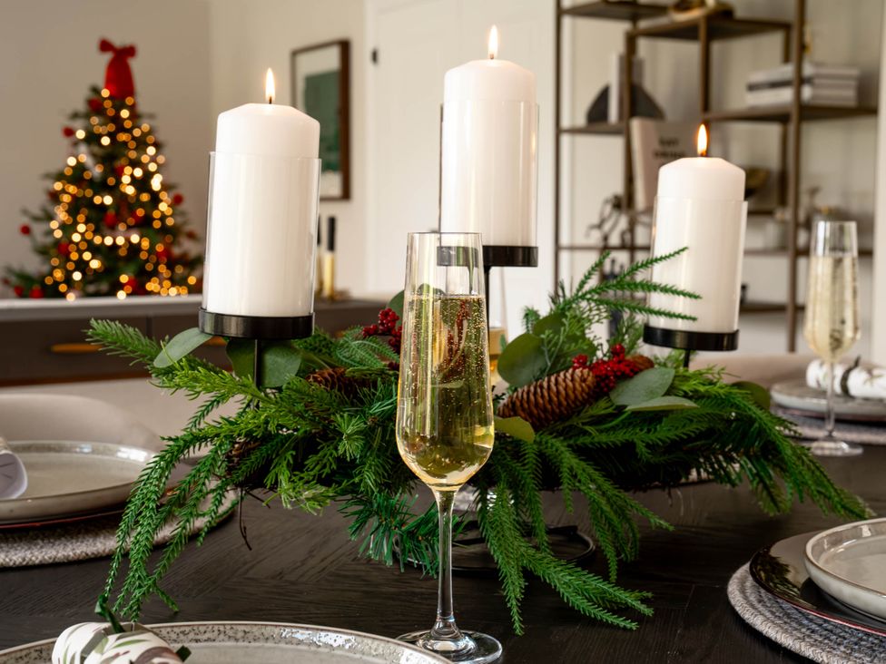 A dining room table with candles and champagne at Sea Estate House Rustington
