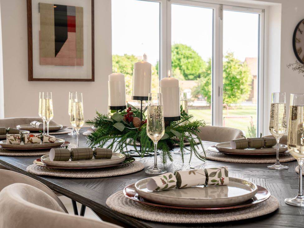A dining room with a table set for a meal at Sea Estate House in Rustington