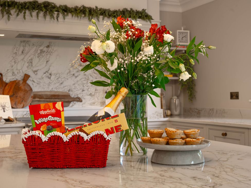 A kitchen with a flower vase and snacks on a counter at Sea Estate House in Rustington