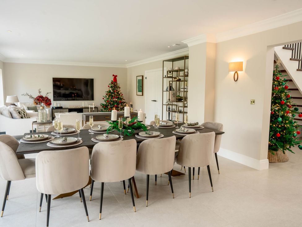 A dining room with a table set and a Christmas tree at Sea Estate House Rustington