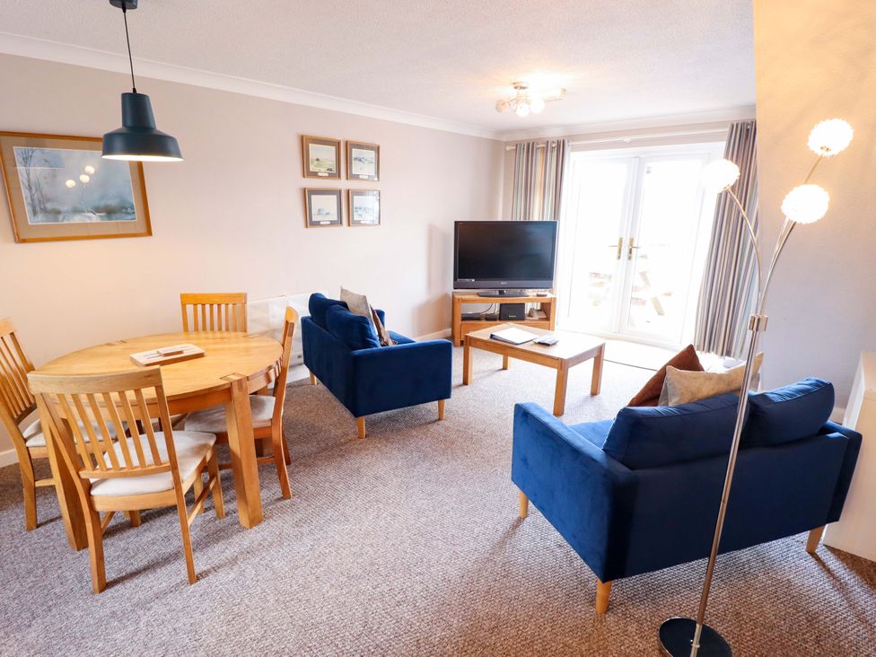 A living room with a dining table and chairs at Grebe Cottage in Norwich