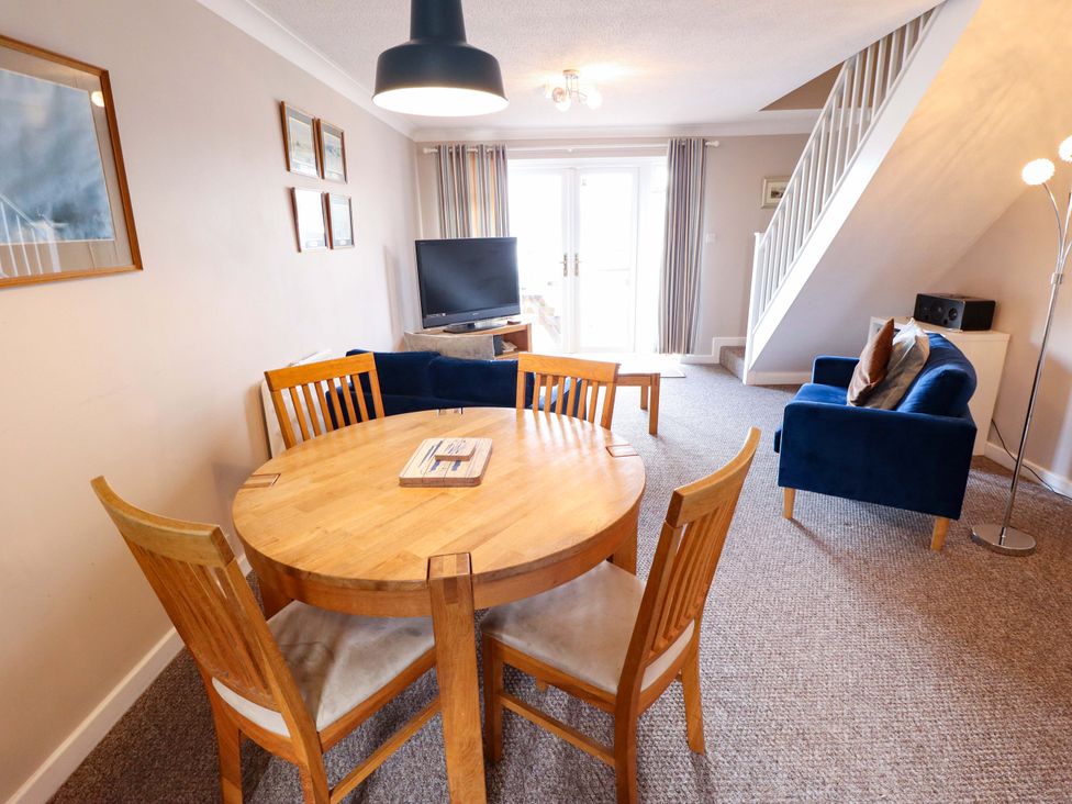 A living room with a dining table and sofa at Grebe Cottage Norwich