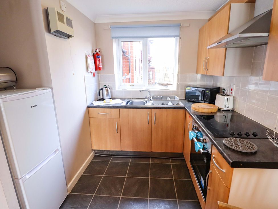 A kitchen with appliances and countertop at Grebe Cottage in Norwich