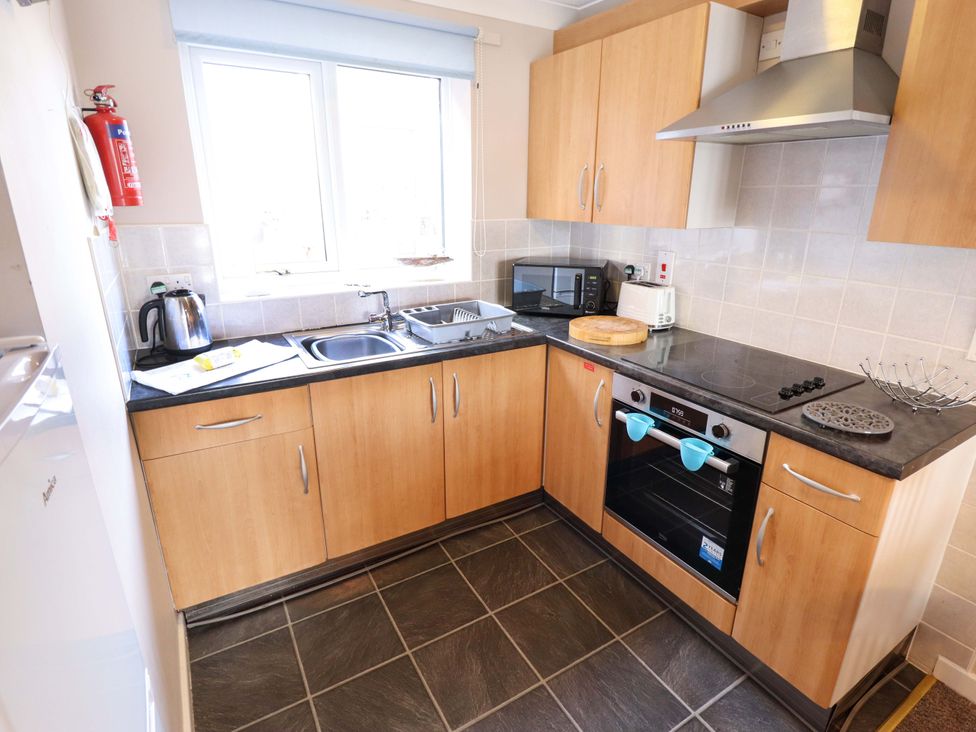 A kitchen with cabinets and appliances at Grebe Cottage in Norwich