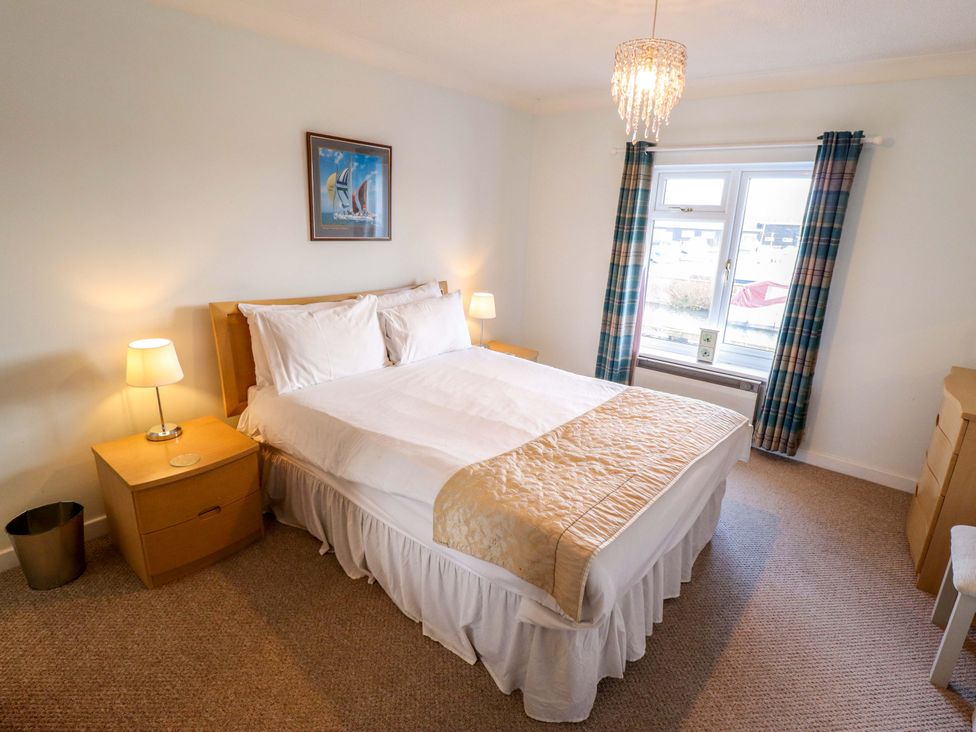 A bedroom with a bed and a nightstand at Grebe Cottage in Norwich