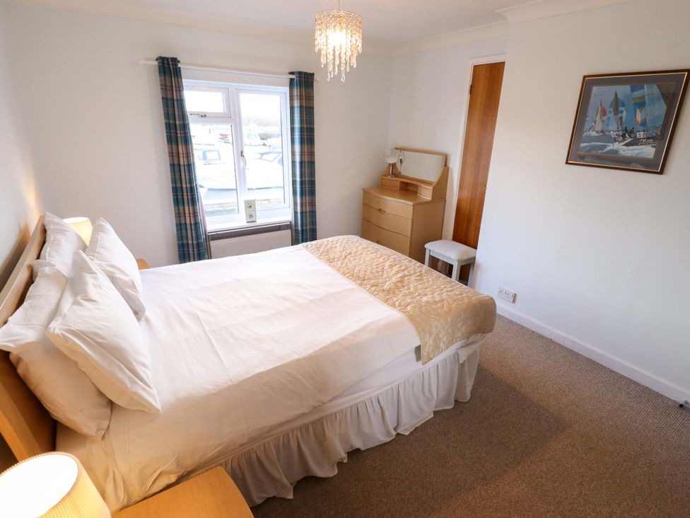 A bedroom with a bed and dressing table at Grebe Cottage, Norwich