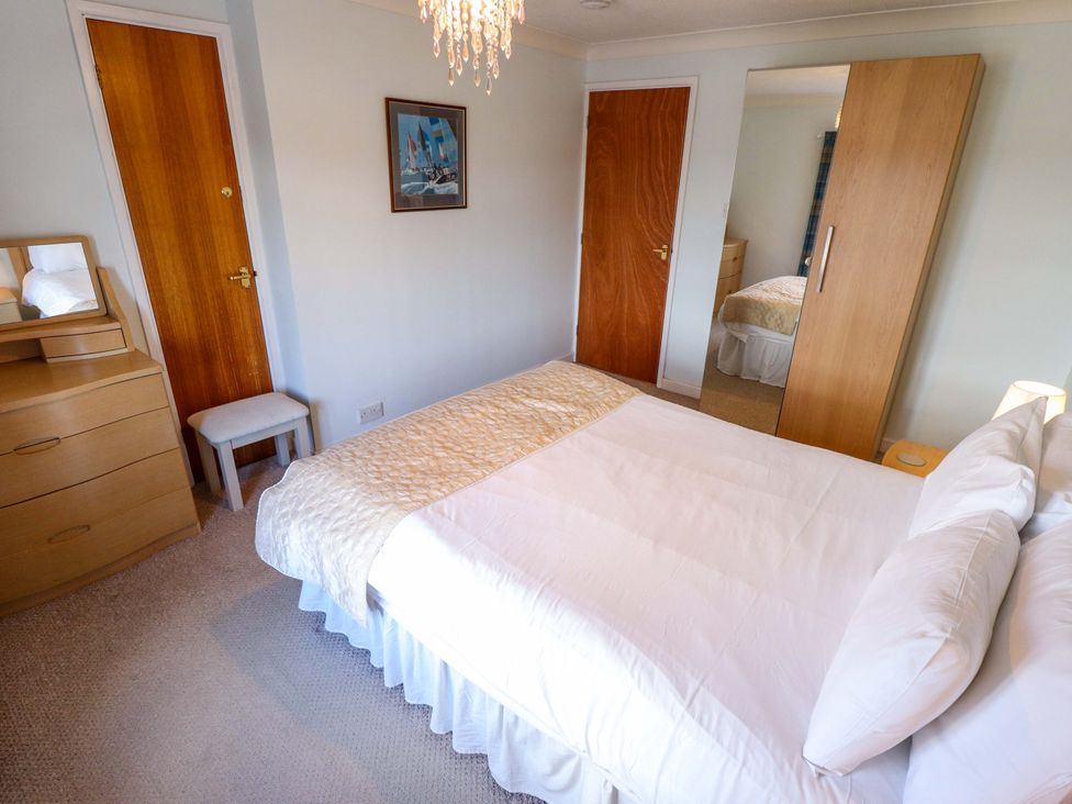 A bedroom with a bed and dressing table at Grebe Cottage in Norwich