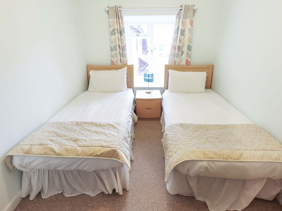 A bedroom with two single beds at Grebe Cottage in Norwich