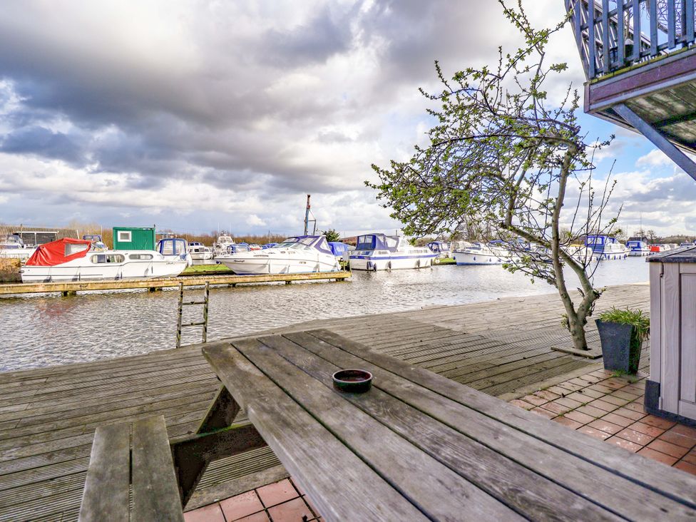 A view of boats docked at the marina from a wooden platform at Grebe Cottage in Norwich