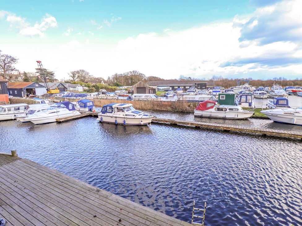 A view of boats on water near a dock at Grebe Cottage in Norwich
