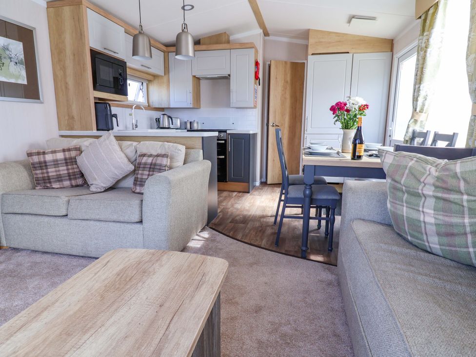 A living room with a kitchen and dining area at The Retreat in Prestatyn