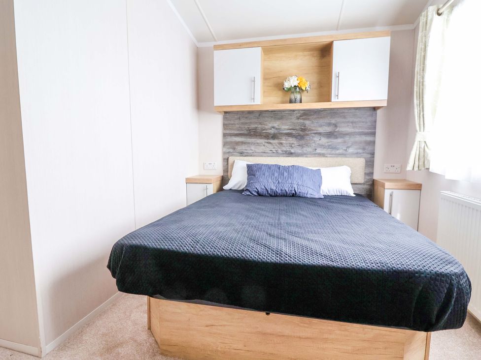 A bedroom with a bed and decorative flowers at The Retreat in Prestatyn