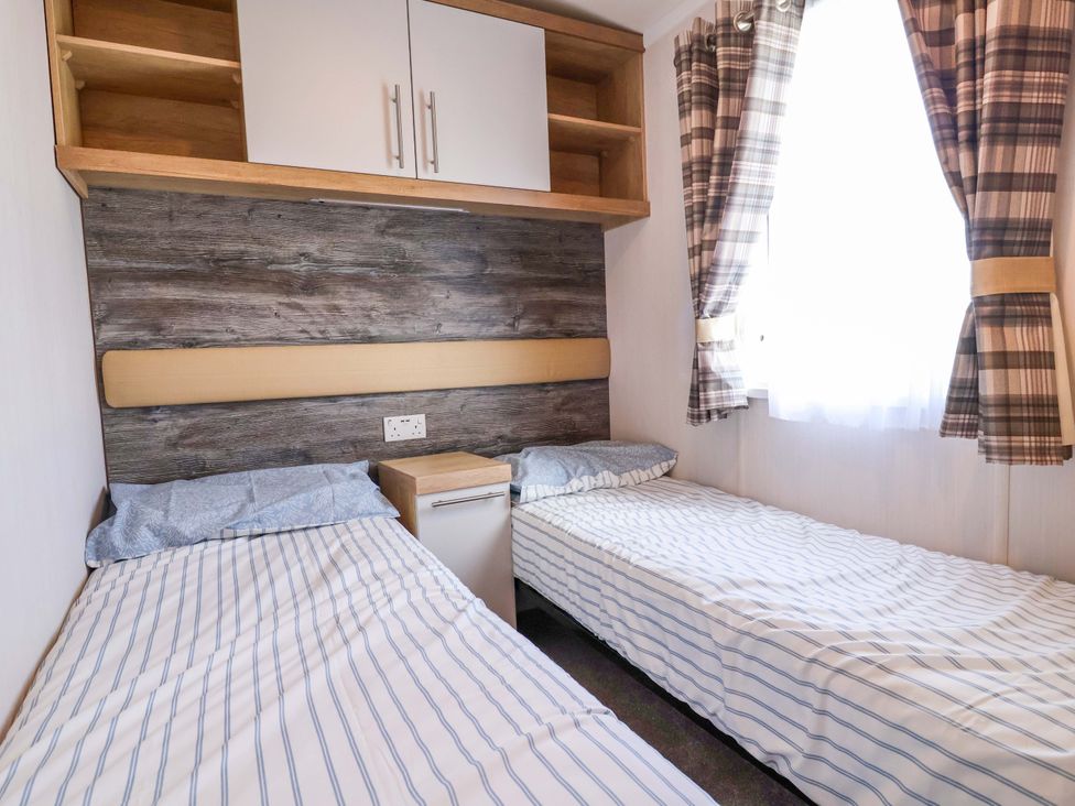 A bedroom with two beds and a window at The Retreat in Prestatyn