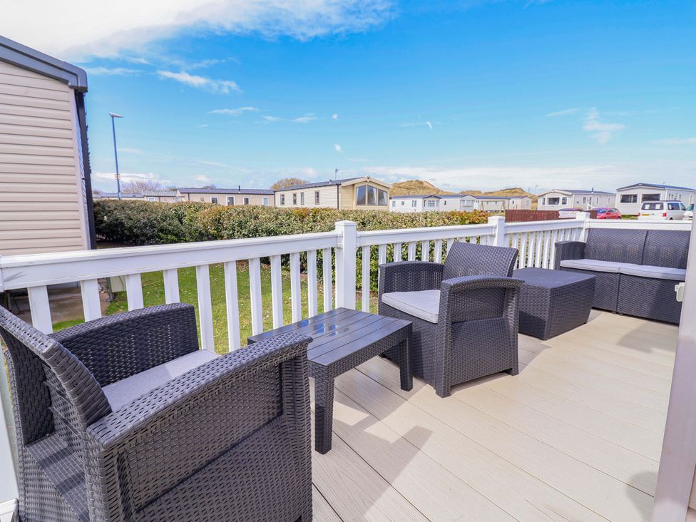 An outdoor seating area with a table and chairs at The Retreat in Prestatyn