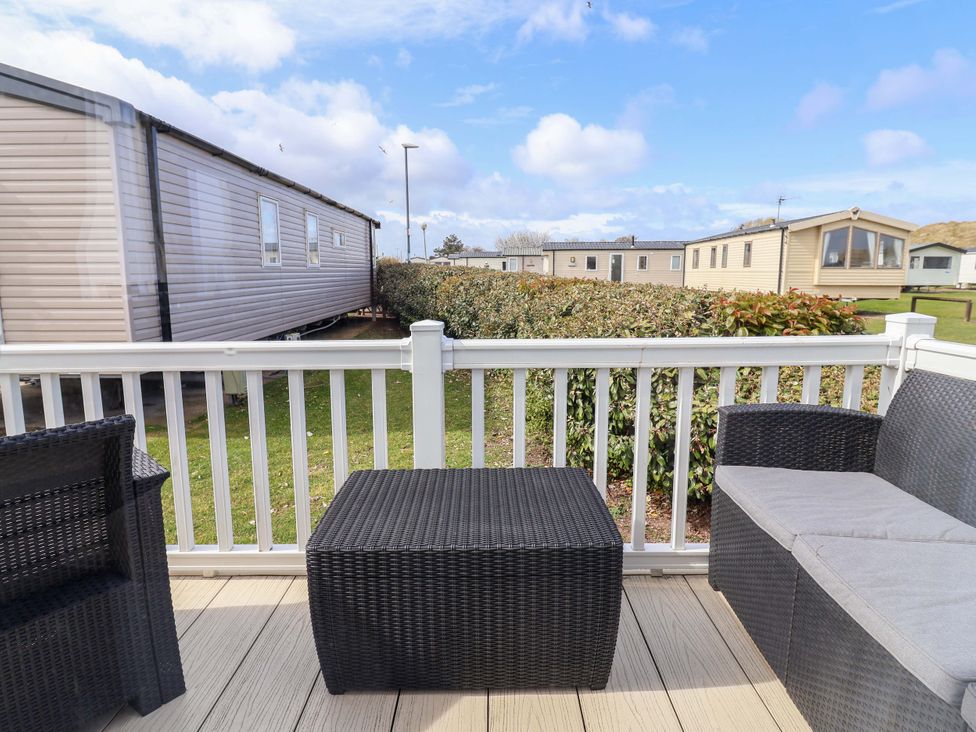 A patio area with a table and chairs at The Retreat in Prestatyn