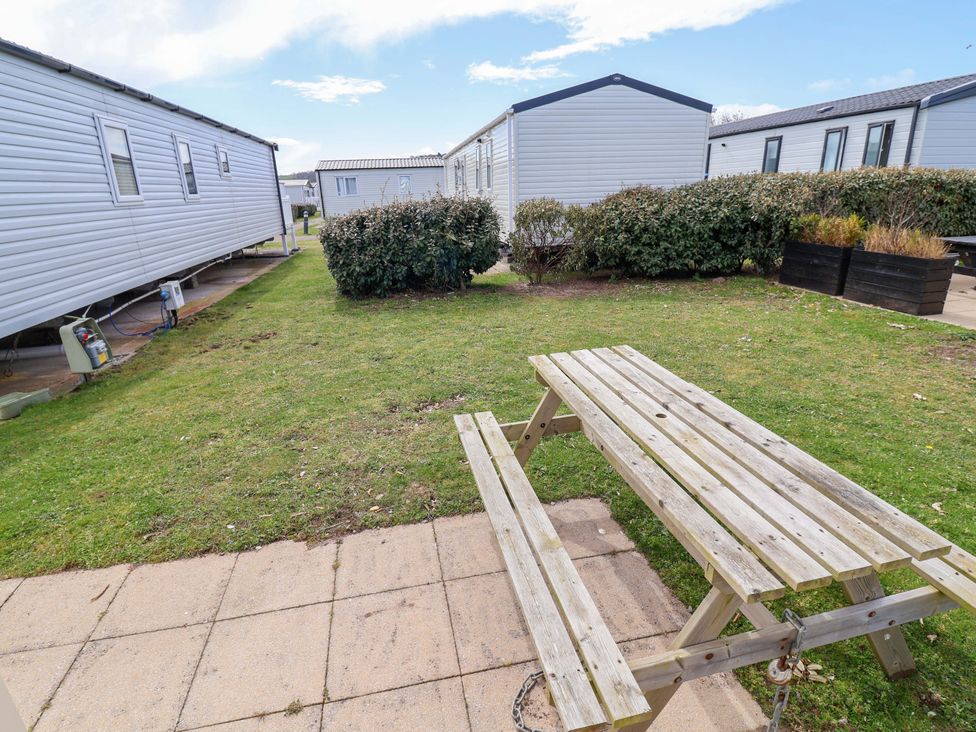 An outdoor space with static caravans and a picnic table at The Retreat in Prestatyn