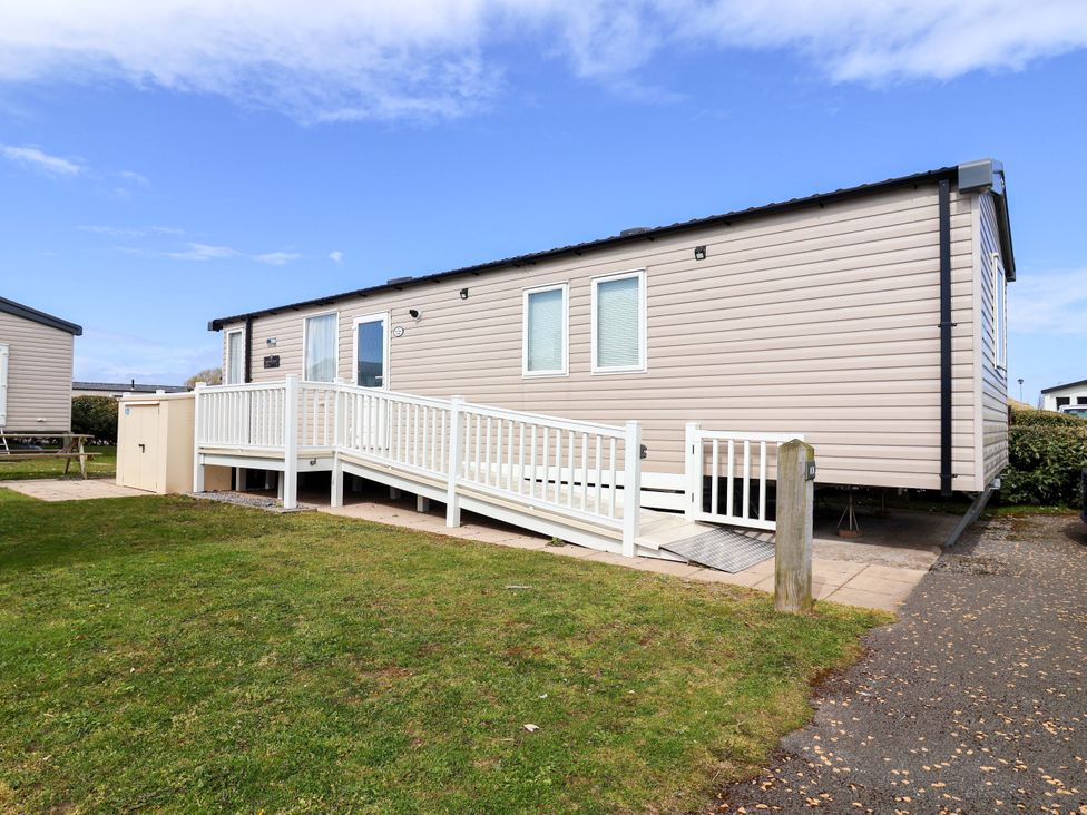A mobile home with a deck and ramp at The Retreat in Prestatyn