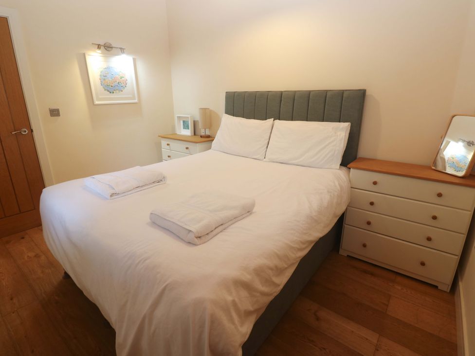 A bedroom with a bed, nightstand, and drawers at The Lodge at Lamburn