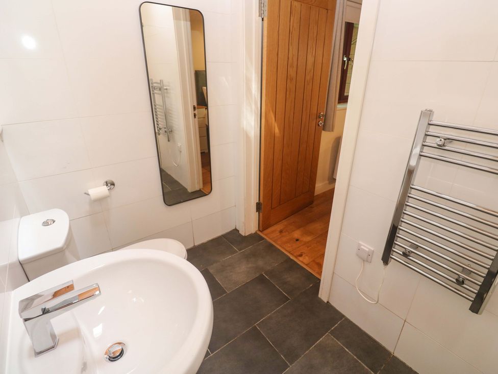 A bathroom with a sink, toilet, and mirror at The Lodge at Lamburn