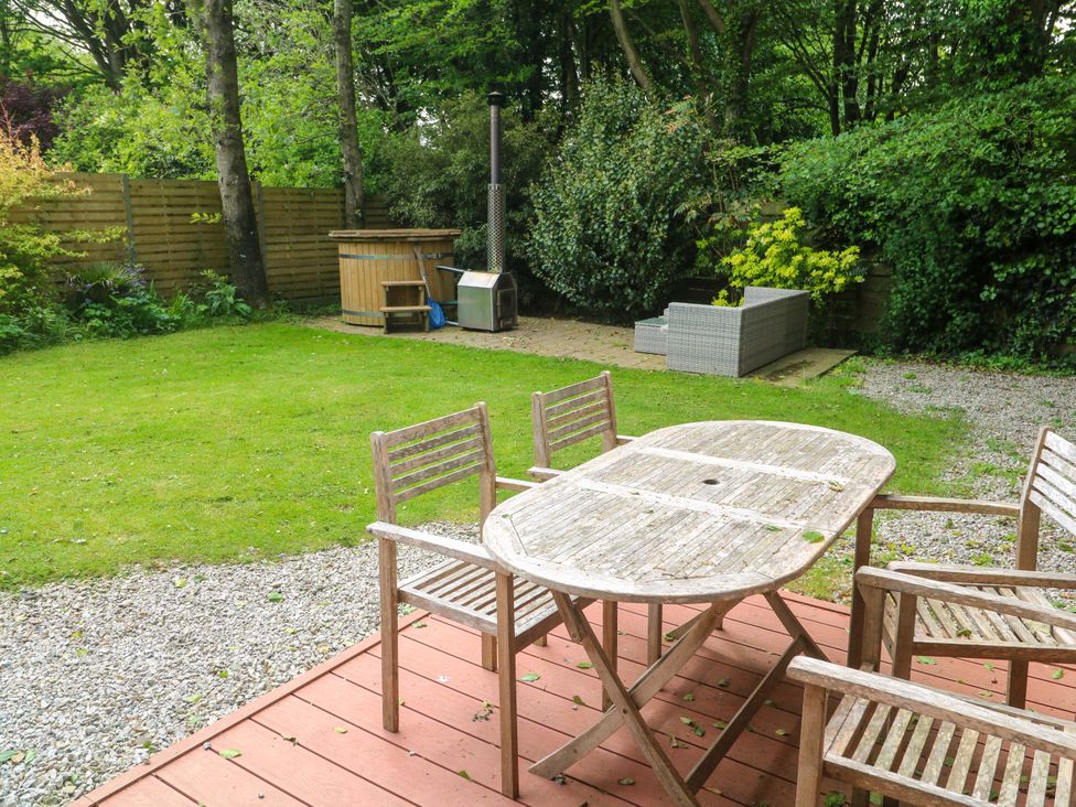 A garden with a table and chairs on a deck at The Lodge at Lamburn