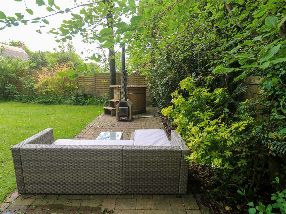 A garden with an outdoor sofa and hot tub at The Lodge at Lamburn