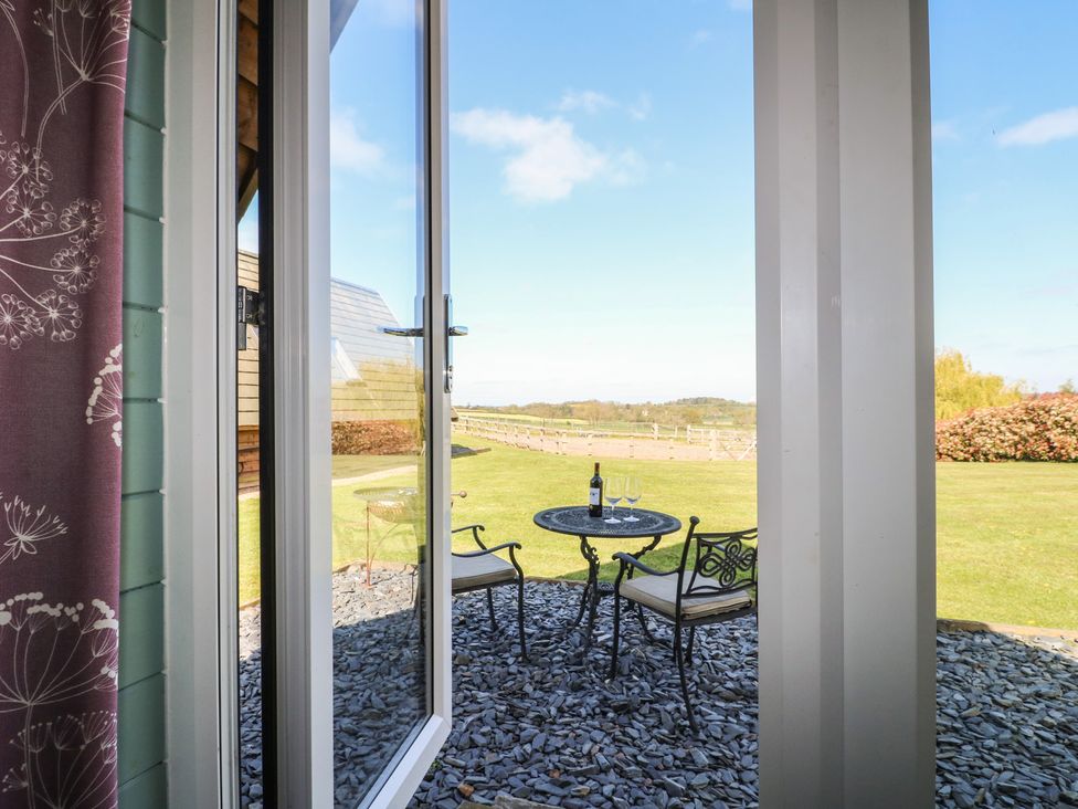 A patio area with a table and chairs visible through a window at Skylark in Loughborough