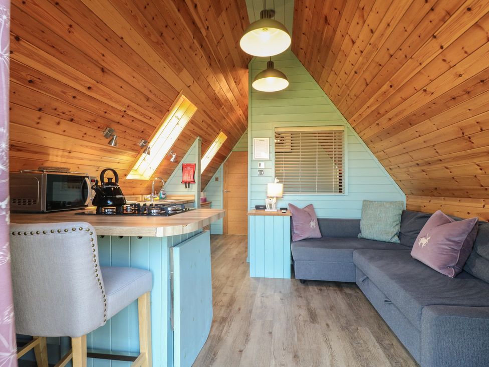 A living room with a kitchen area and seating at Skylark in Loughborough