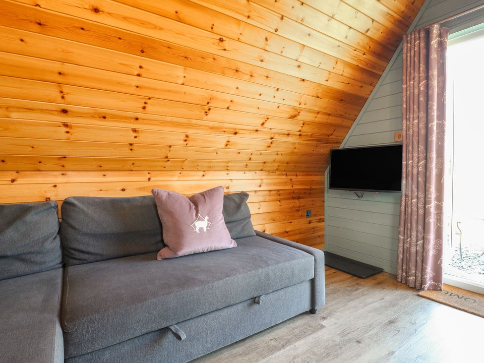 A living room with a sofa and television at Skylark in Loughborough