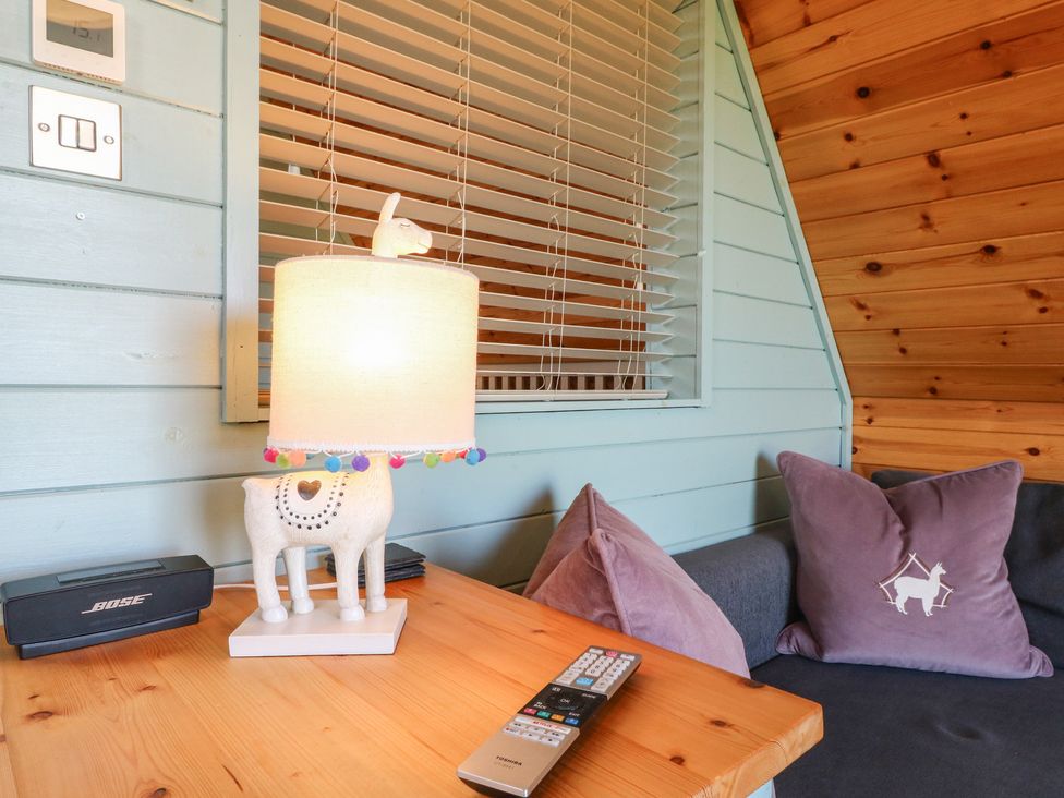 A living room with a lamp and cushions at Skylark in Loughborough