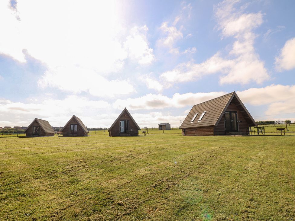 A view of multiple cabins with grass and sky at Skylark in Loughborough