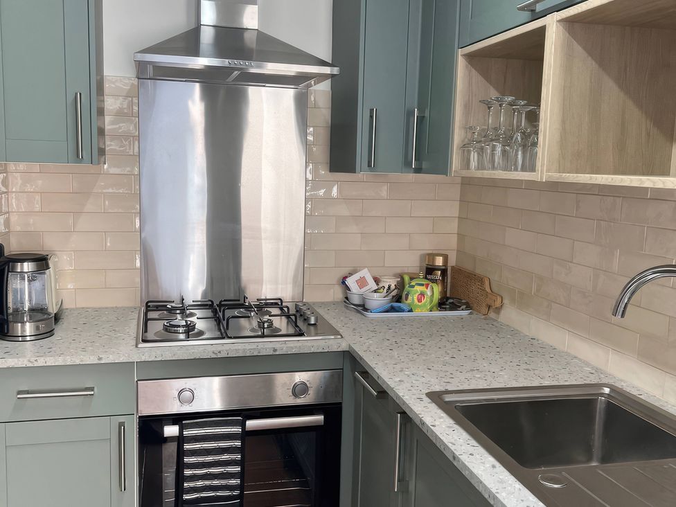 A kitchen with gas stove and sink at 3 Newboro Terrace in Conwy