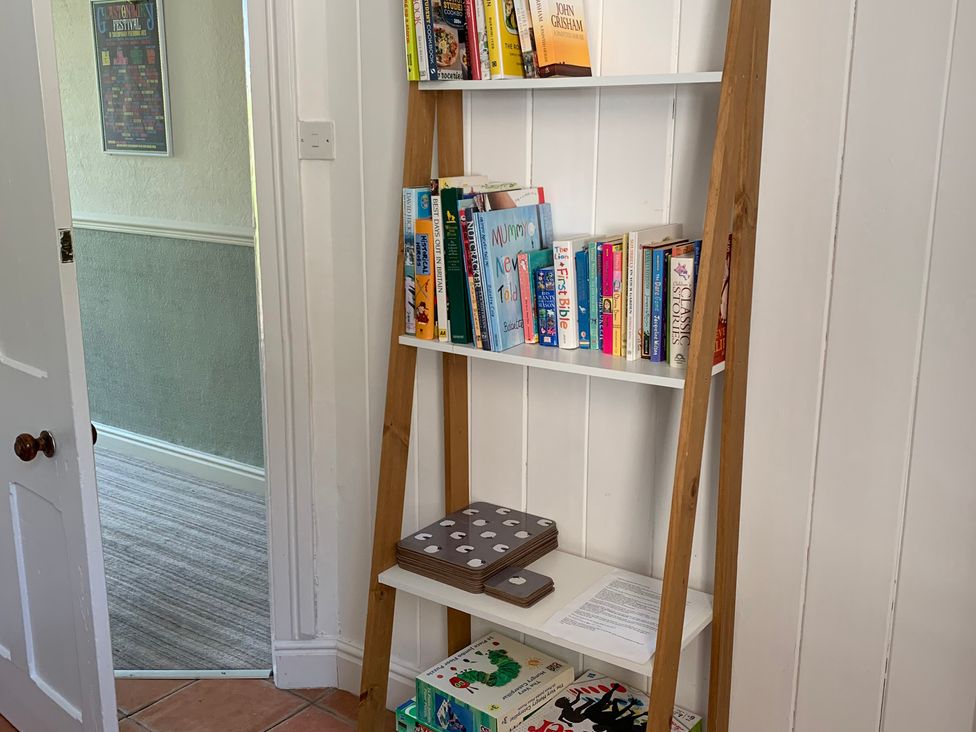 A bookshelf with books and games in a hallway at 3 Newboro Terrace, Conwy