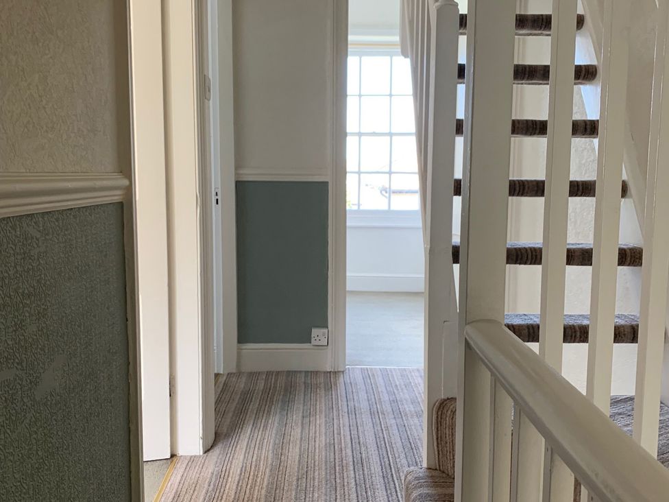 A hallway with a staircase and a window at 3 Newboro Terrace in Conwy