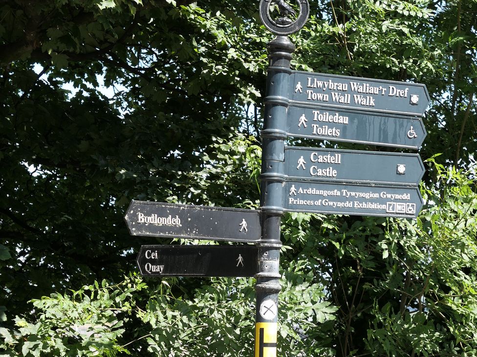 A signpost indicating directions to Town Wall Walk, Toilets, Castle, and Quay at 3 Newboro Terrace Conwy