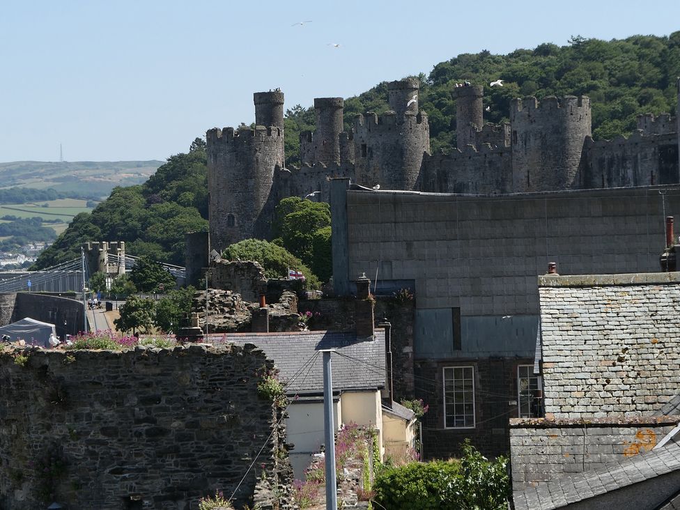 A view of castle walls surrounded by trees and buildings at 3 Newboro Terrace in Conwy