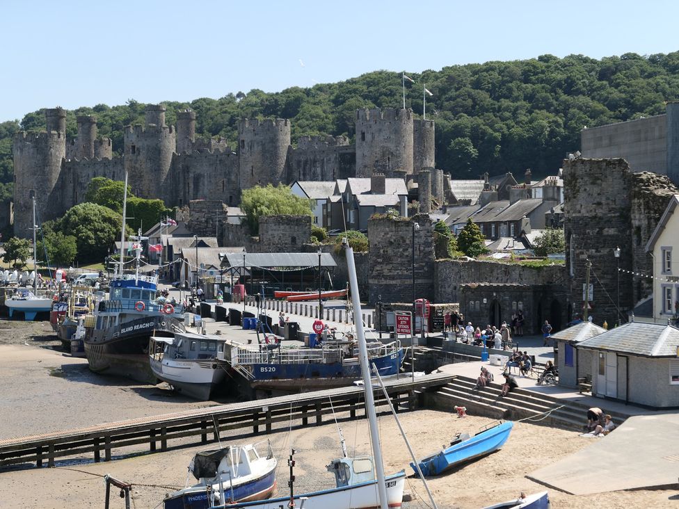 A dock with boats and a castle in the background at 3 Newboro Terrace in Conwy