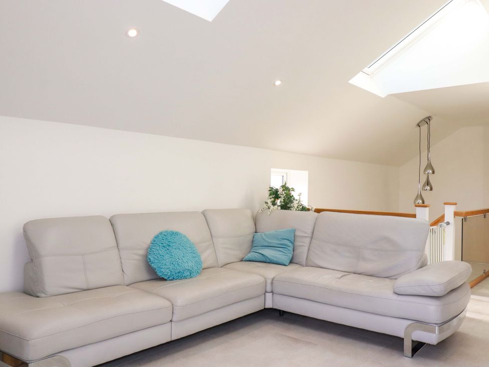 A living room with a sofa and cushion at Meadow Retreat in Bodmin