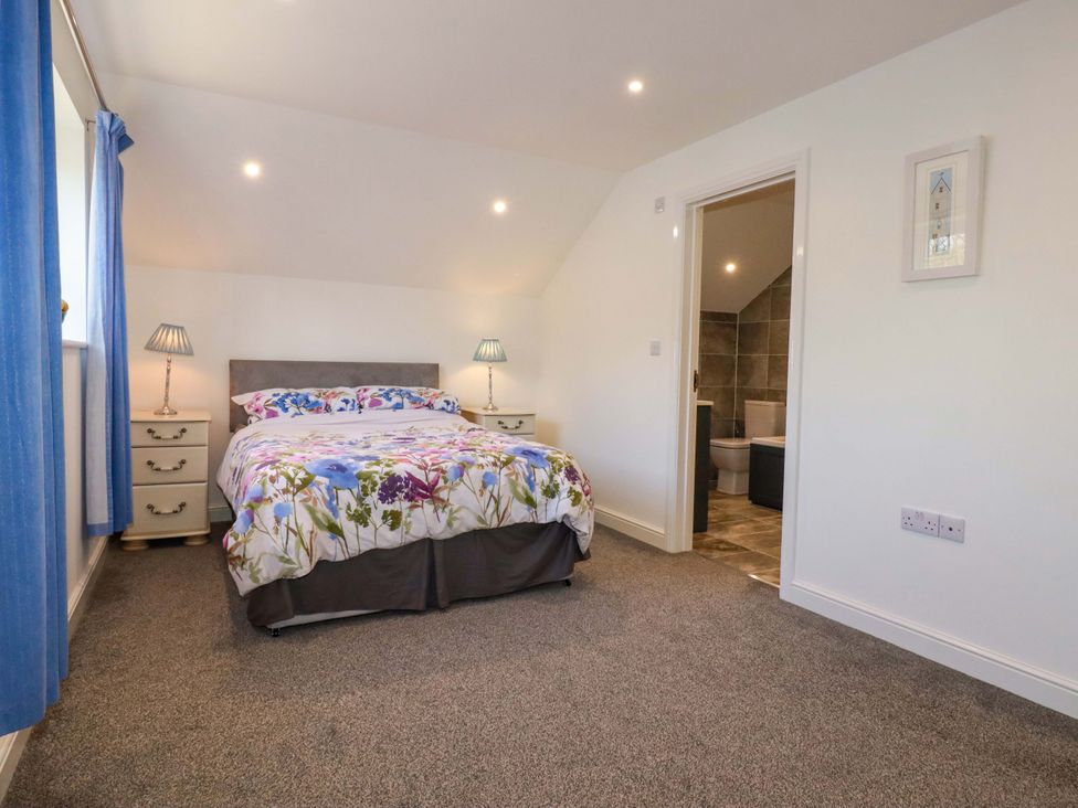 A bedroom with a bed and nightstands at Meadow Retreat in Bodmin