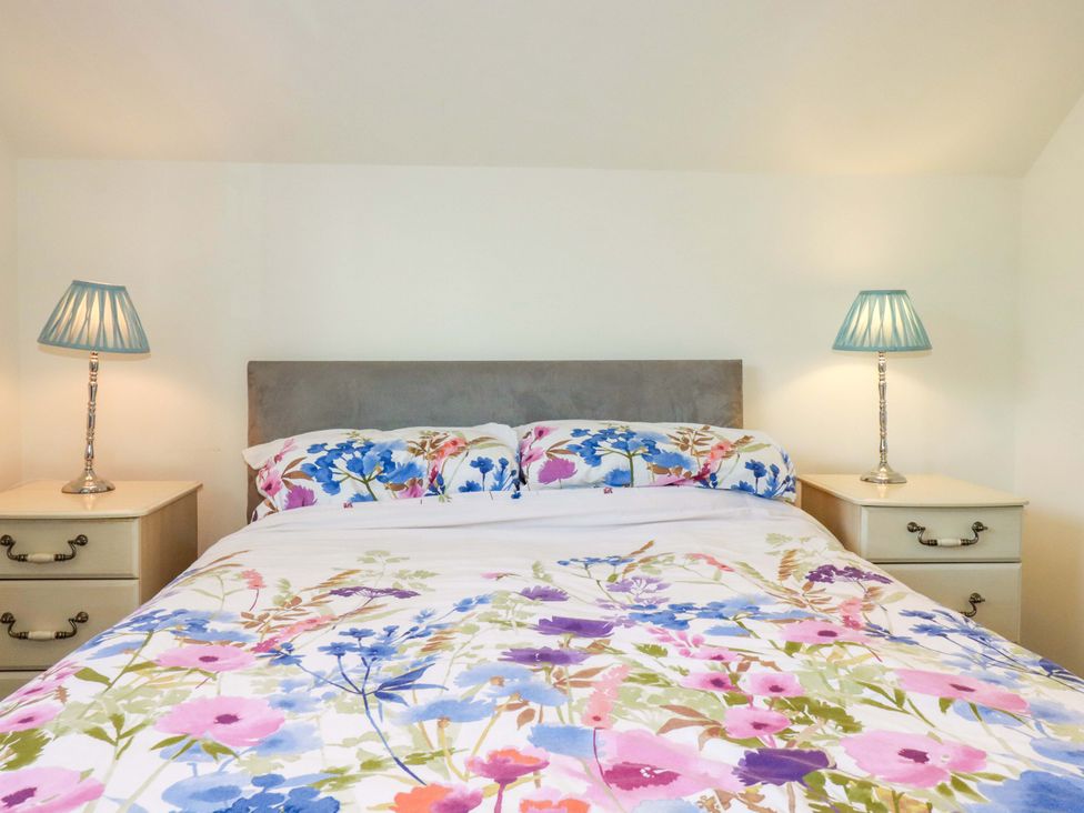 A bedroom with a bed and bedside tables at Meadow Retreat in Bodmin