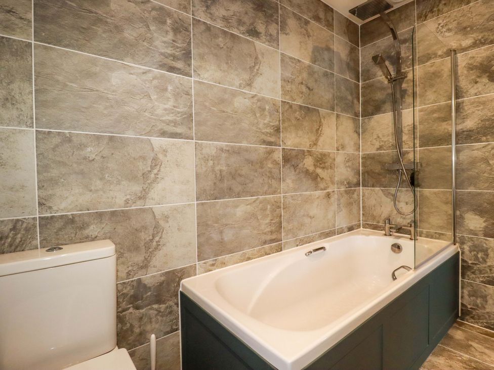 A bathroom with a bathtub and toilet at Meadow Retreat in Bodmin