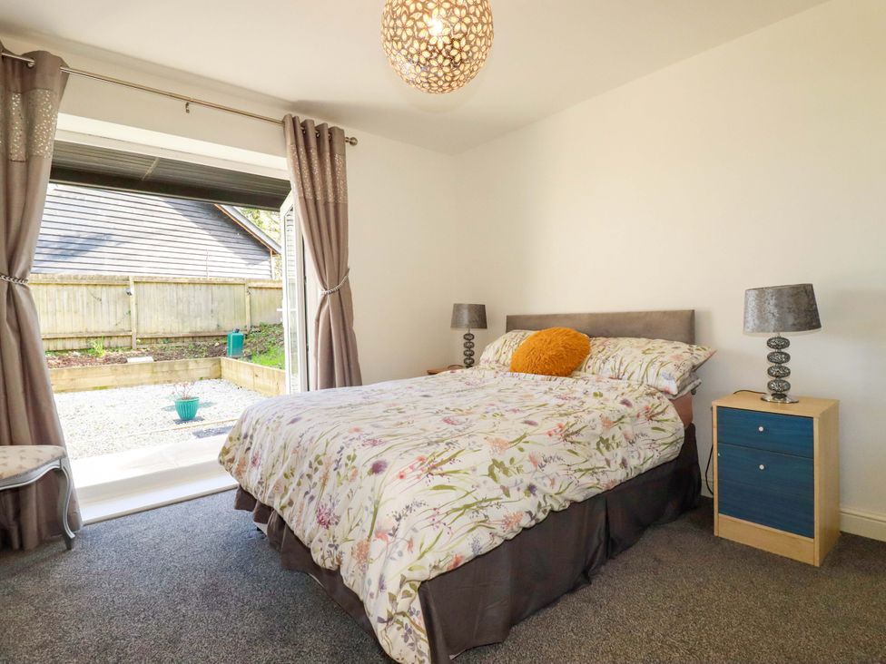 A bedroom with a bed and bedside table at Meadow Retreat in Bodmin
